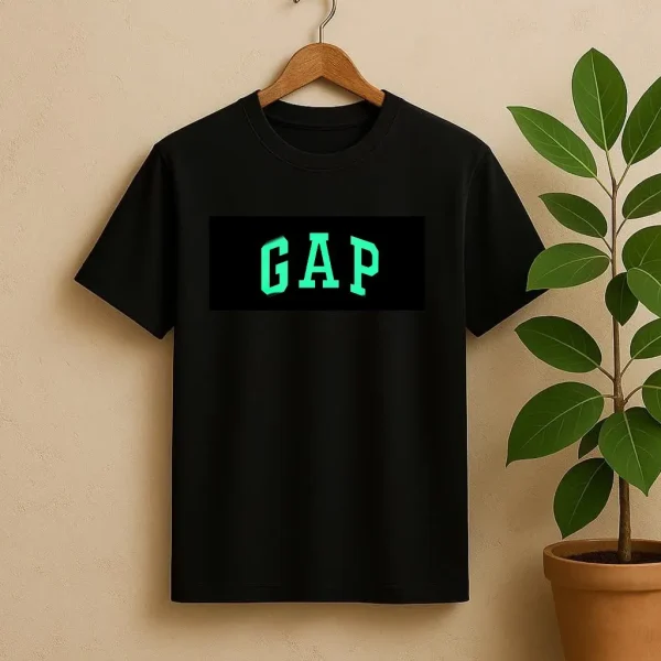 تیشرت مشکی شب‌نما با چاپ نئونی لوگوی برند GAP به رنگ سبز فسفری، مناسب استایل‌های روزمره، خیابانی و کژوال